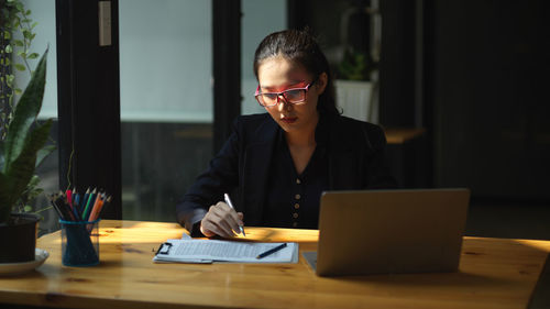 Young man using laptop at desk in office