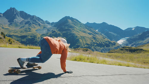 Rear view of woman walking on snowcapped mountain