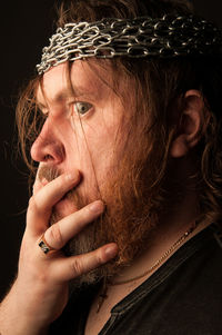 Close-up portrait of mid adult man against black background