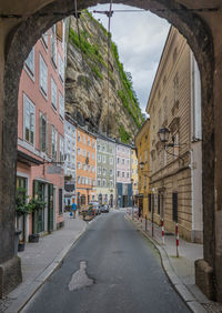 Empty road amidst buildings in city