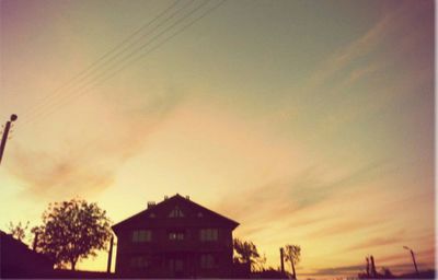 Low angle view of buildings against sky at sunset