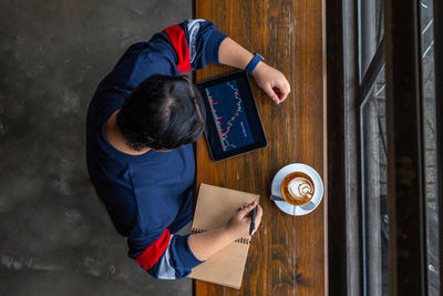 Directly above shot of woman looking at graph in cafe