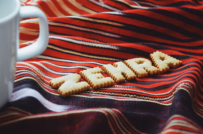 High angle view of cookies with coffee cup on fabric