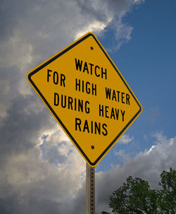 Low angle view of road sign against sky