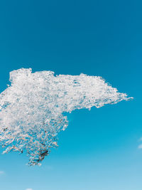 Close-up of snow against clear blue sky