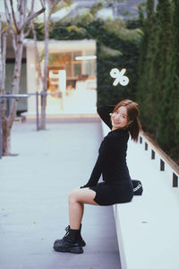 Portrait of young woman standing on street