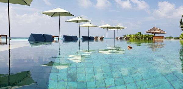 View of swimming pool by sea against sky