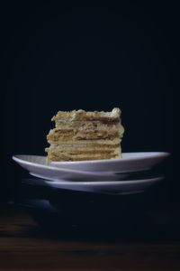 Close-up of cake on table against black background