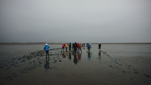 People at beach against sky