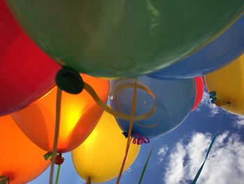 Low angle view of colorful balloons against sky