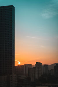 Modern buildings against sky during sunset in city