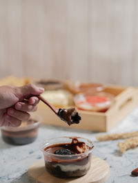 Midsection of person holding wood spoon on table