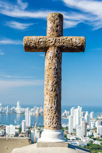 Stone cross against cityscape