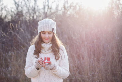 Portrait of young woman standing in park