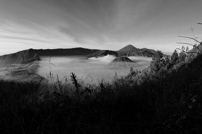 Scenic view of land and mountains against sky