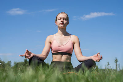 Healthy and active lifestyle. sports and fitness. sportive woman meditating sitting on grass