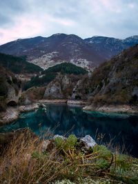 Scenic view of lake and mountains against sky