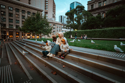 Rear view of people walking on street in city