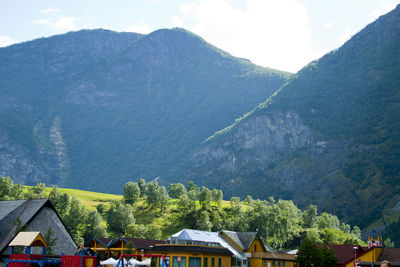 Houses by trees and mountains against sky