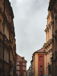 Low angle view of buildings against cloudy sky