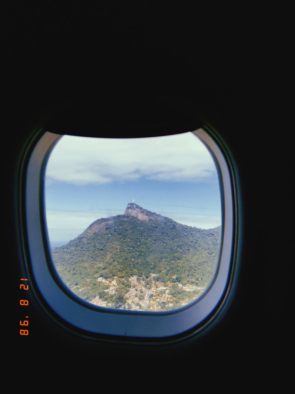 window, airplane, transportation, mode of transportation, sky, air vehicle, vehicle interior, travel, flying, nature, mountain, scenics - nature, glass, aerial view, cloud, no people, landscape, environment, blue, beauty in nature, transparent, outdoors, day, mid-air, journey, mountain range, looking through window, land, light, travel destinations, looking, reflection, screenshot, copy space