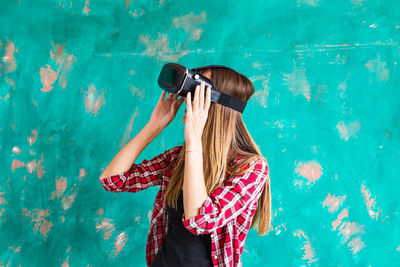 Woman standing outdoors wearing virtual reality headset