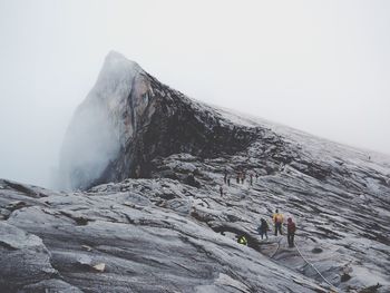 View of hikers climbing rocks