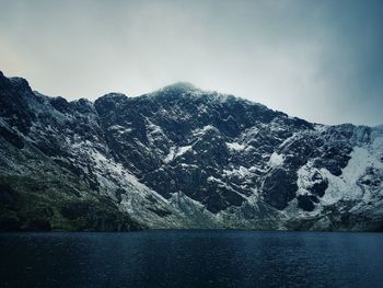 Scenic view of lake by mountains against sky