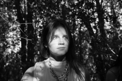 Portrait of young woman looking away in forest