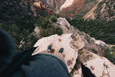 Low section of man on rock by mountain