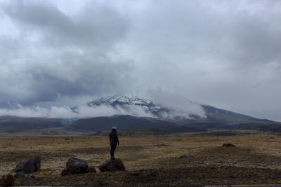 Man on field against mountain range