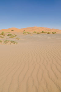 Scenic view of desert against clear blue sky