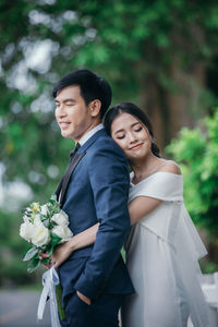 Portrait of a young couple standing against blue sky