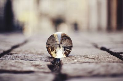 Buildings reflecting in crystal ball on footpath