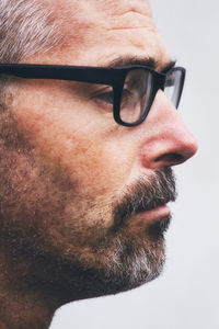 Close-up of man looking away against white background