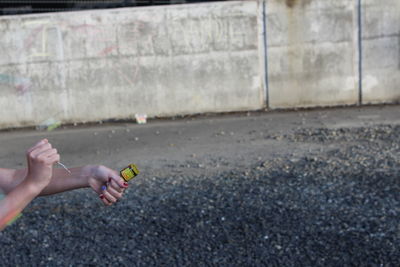 Young man holding camera on street