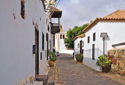 Narrow street amidst buildings against sky