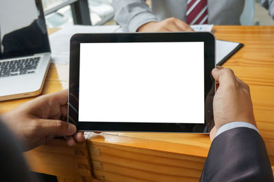 Midsection of businessman using digital tablet