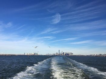 Wake in river against sky