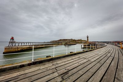 View of pier on sea against cloudy sky