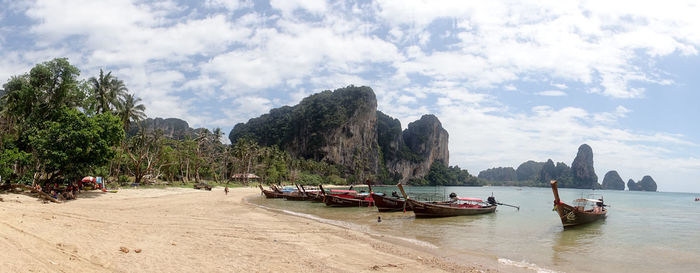 Panoramic view of people on beach against sky