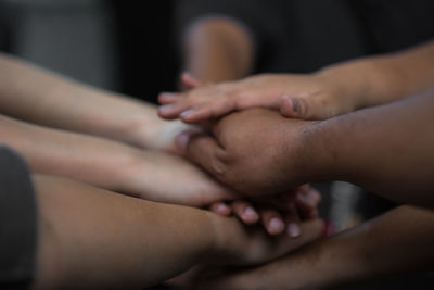 Cropped image of friends stacking hands