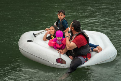 Man with children floating on lake