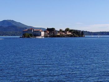 Scenic view of sea by buildings against sky