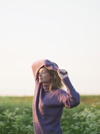 Smiling woman standing on field during sunrise