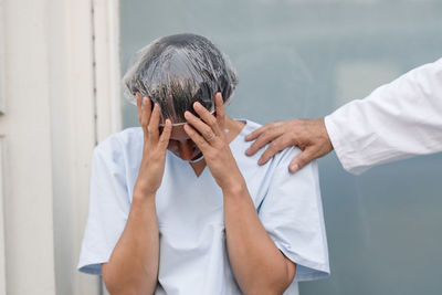 Frustrated doctor holding her head grieving realising her mistakes. colleague is comforting her