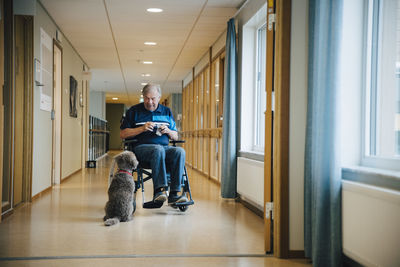 Man sitting on seat in corridor