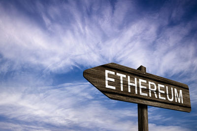 Low angle view of road sign against sky