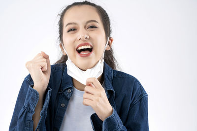 Portrait of smiling young woman against white background