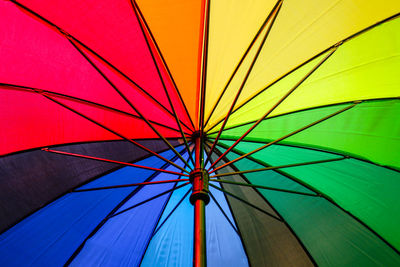 Low angle view of multi colored umbrella against blue sky